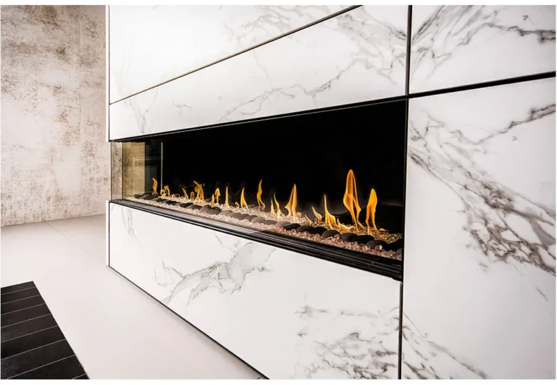 Modern linear Flare Left Corner 100" with 24" high glass fireplace set in a polished white marble wall with luxurious design elements. LC-100