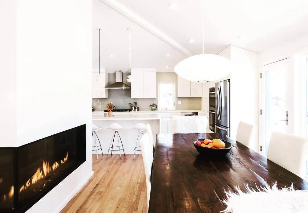 Modern open-concept dining and kitchen area with a sleek linear Flare Left Corner 80" Fireplace. LC-80