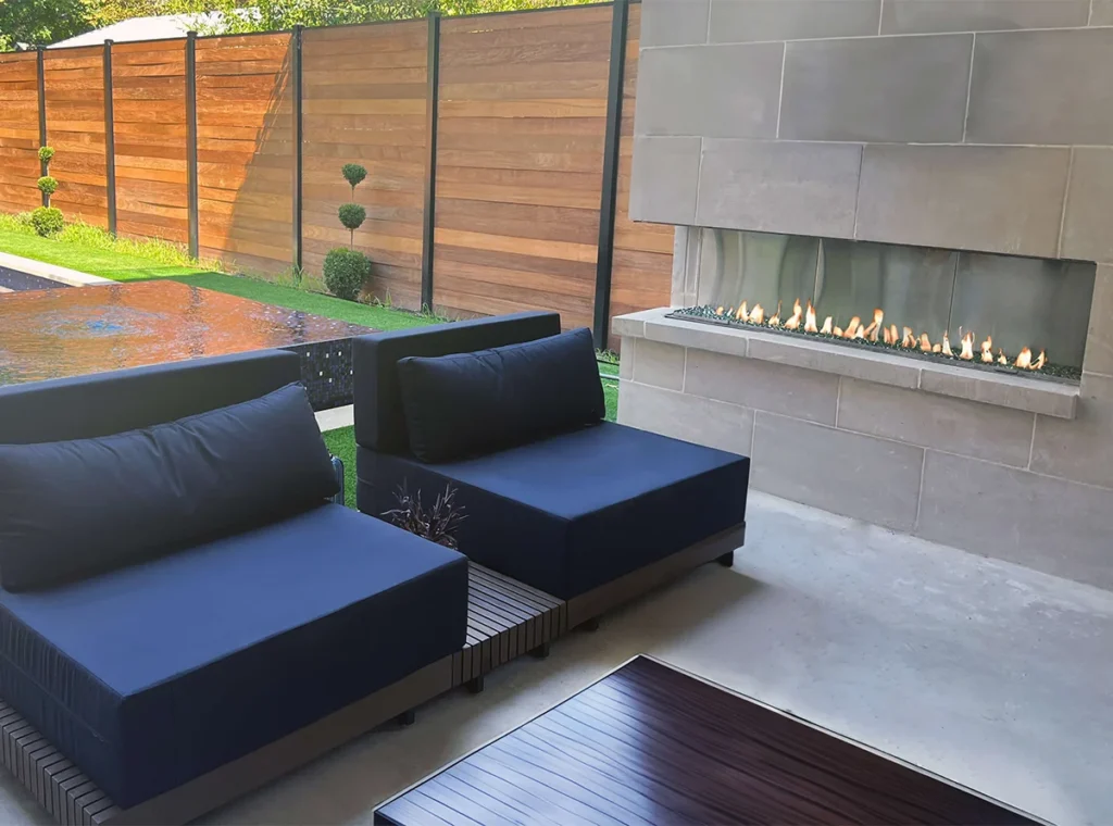 Contemporary patio seating paired with a stone-clad outdoor gas fireplace, showcasing a modern linear design.