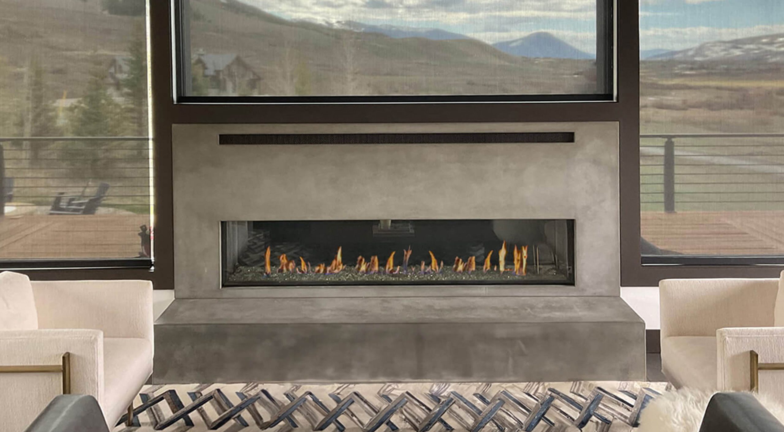 Front Facing 100 R linear direct vent fireplace in a modern concrete feature wall with mountain views