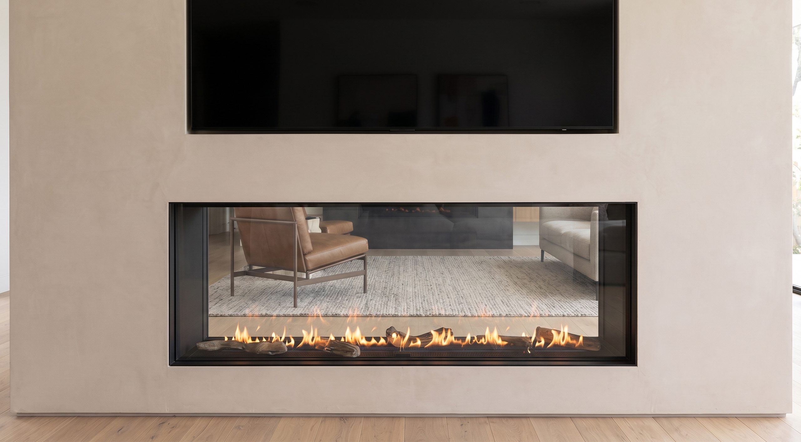 See Through 80 x 30 gas fireplace with driftwood log media in a modern plaster feature wall
