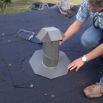 Installer fitting a vertical J-type termination cap over the Flare Summer Kit vent pipe on a roof