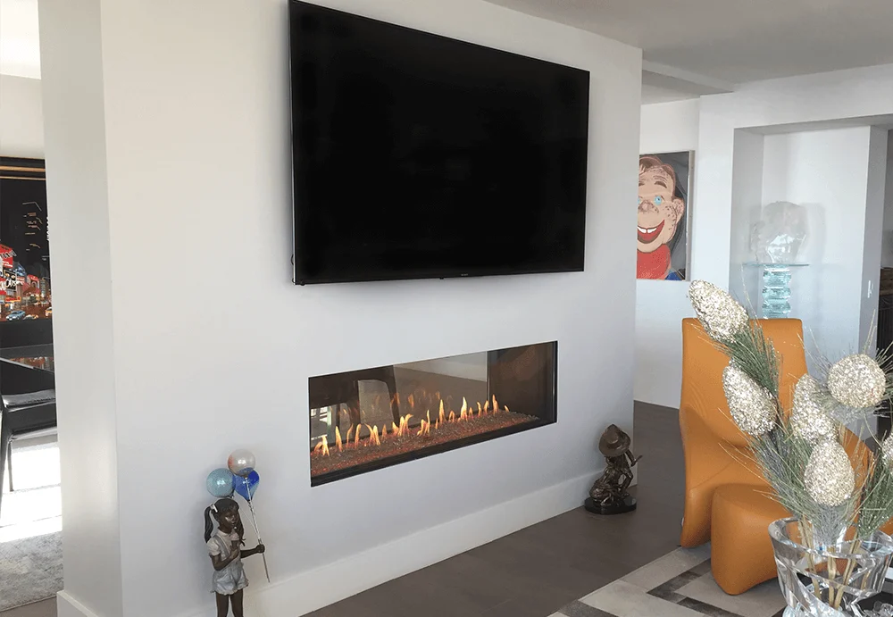Flare See-Through 60 double-sided gas fireplace below a wall-mounted TV in a contemporary living room, frameless linear opening
